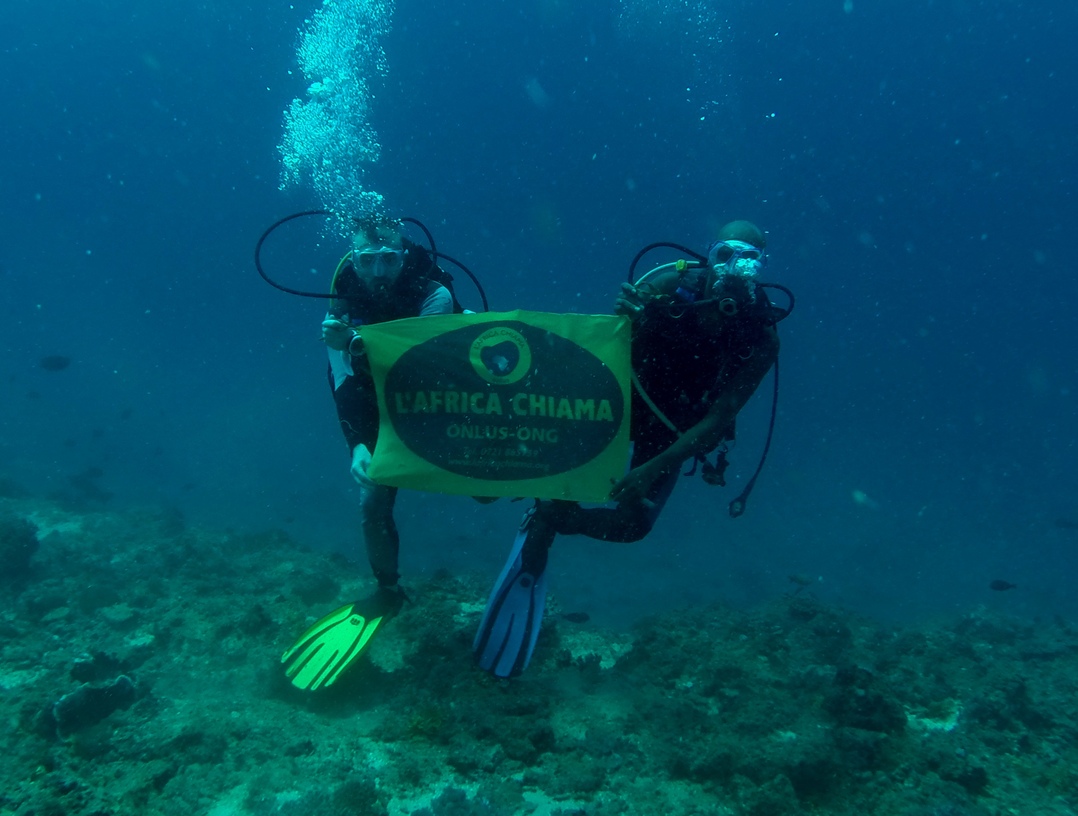 marcello madeddu volontario sott'acqua con la bandiera L'Africa Chiama